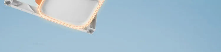 Rectangular ceiling light fixture with orange-lit border against a blue sky.